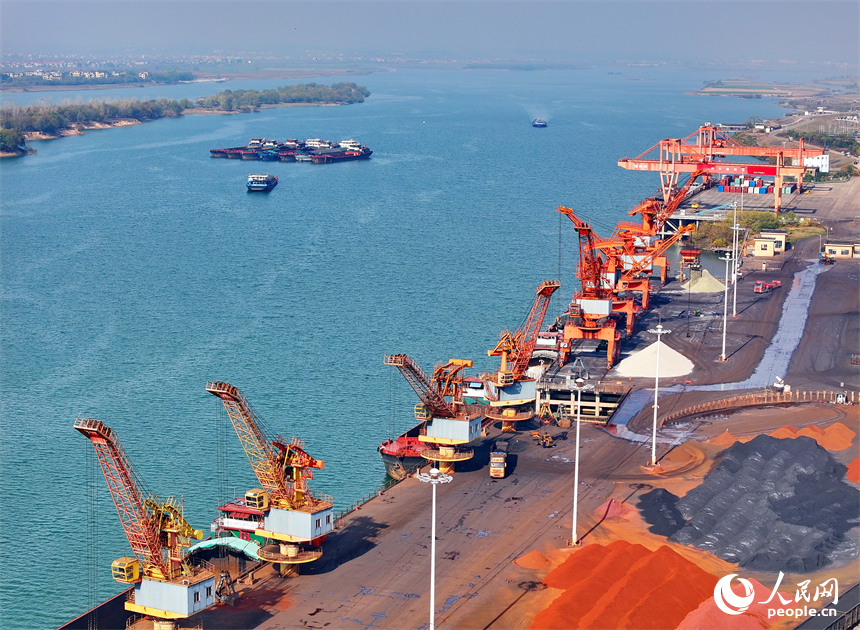 樟樹市樟樹港大碼頭，貨輪、貨車往來穿梭，吊裝運輸作業繁忙有序。人民網 朱海鵬攝