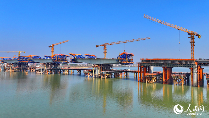 南昌隆興大橋南及連接線工程跨贛江南支引橋建設工地塔吊林立，工人在有序推進橋梁澆筑架設作業。人民網 朱海鵬攝