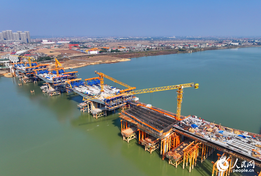 南昌隆興大橋南及連接線工程跨贛江南支引橋建設工地塔吊林立，工人在有序推進橋梁澆筑架設作業。人民網 朱海鵬攝