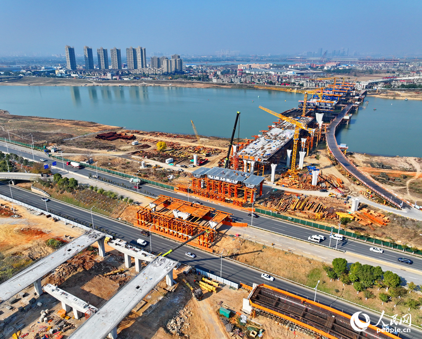 南昌隆興大橋南及連接線工程跨贛江南支引橋建設工地塔吊林立，工人在有序推進橋梁澆筑架設作業。人民網 朱海鵬攝