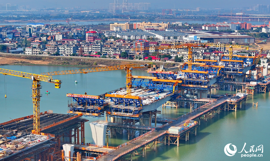 南昌隆興大橋南及連接線工程跨贛江南支引橋建設工地塔吊林立，工人在有序推進橋梁澆筑架設作業。人民網 朱海鵬攝