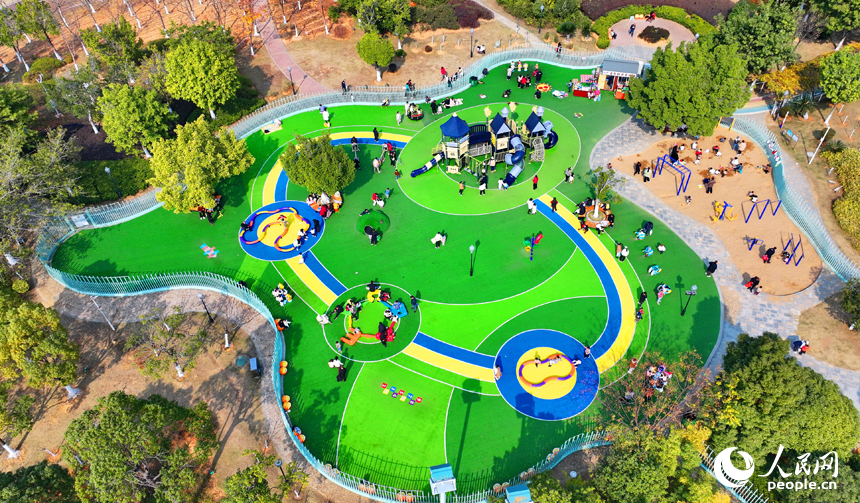 贛州市一處公園里的兒童樂園，許多家長陪伴孩子在公園里玩耍，暢享冬日暖陽，體驗新添置的玩樂設施。人民網 朱海鵬攝