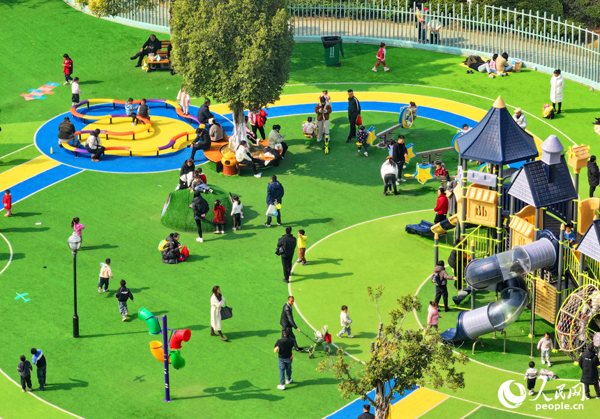 贛州市一處公園里的兒童樂園，許多家長陪伴孩子在公園里玩耍，暢享冬日暖陽，體驗新添置的玩樂設施。人民網 朱海鵬攝