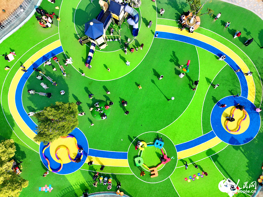 贛州市一處公園里的兒童樂園，許多家長陪伴孩子在公園里玩耍，暢享冬日暖陽，體驗新添置的玩樂設施。人民網 朱海鵬攝