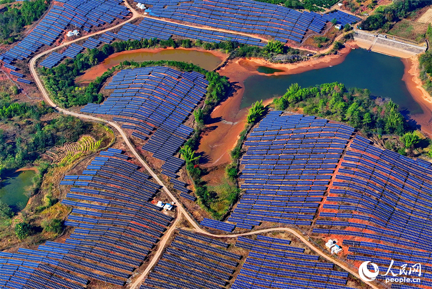 贛州市信豐縣正平鎮的一處農光互補光伏發電基地，太陽能光伏板與青山綠樹、村莊田園相映襯。人民網 朱海鵬攝