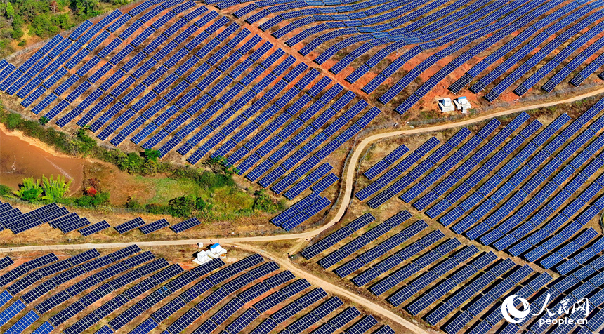 贛州市信豐縣正平鎮的一處農光互補光伏發電基地，太陽能光伏板與青山綠樹、村莊田園相映襯。人民網 朱海鵬攝