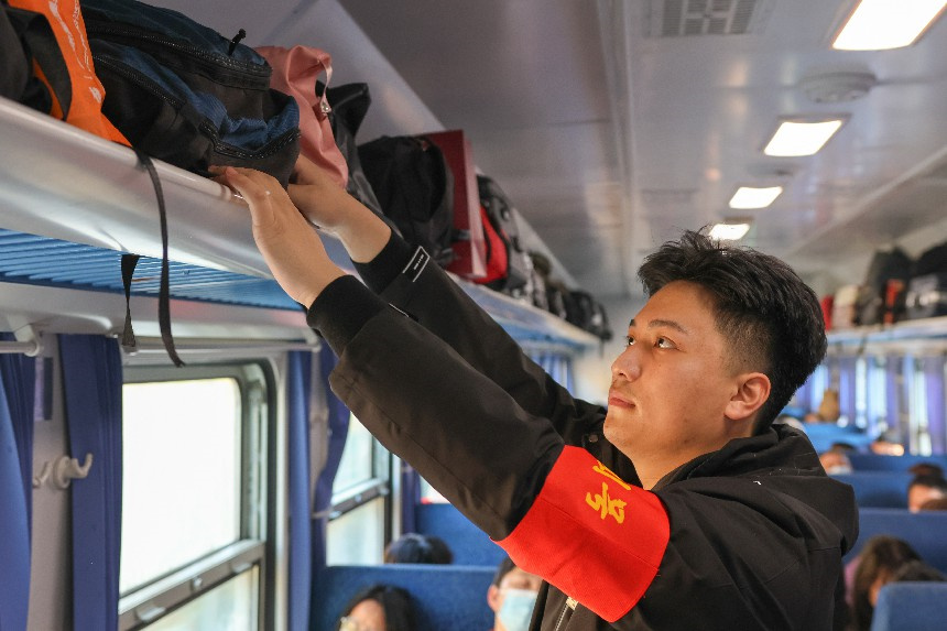 乘務員董科言正整理車廂內乘客行李。李舜攝