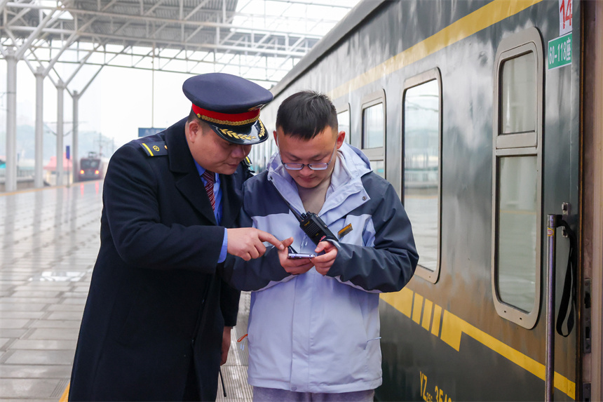 圖為K4280次旅客列車列車長陶志兵幫助乘務員熟悉查驗車票工作流程。王浩 攝