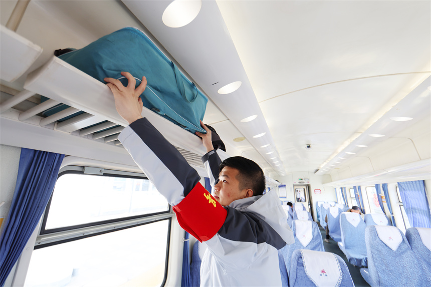 圖為K4280次旅客列車乘務員為旅客搬運行李。 黃鐘濱 攝