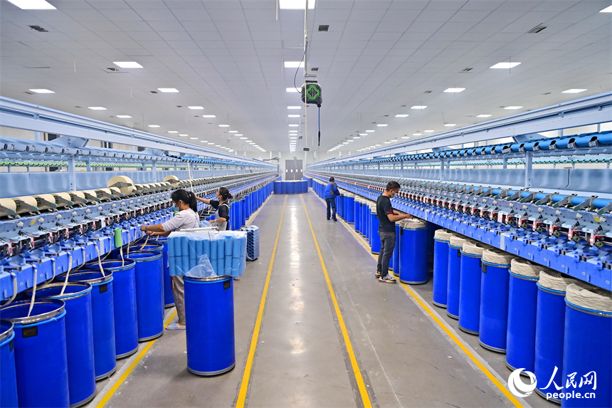 上高縣工業園區的一家民營紡織企業車間內，工人在智能紡紗生產線上加工出口訂單產品。人民網 朱海鵬攝