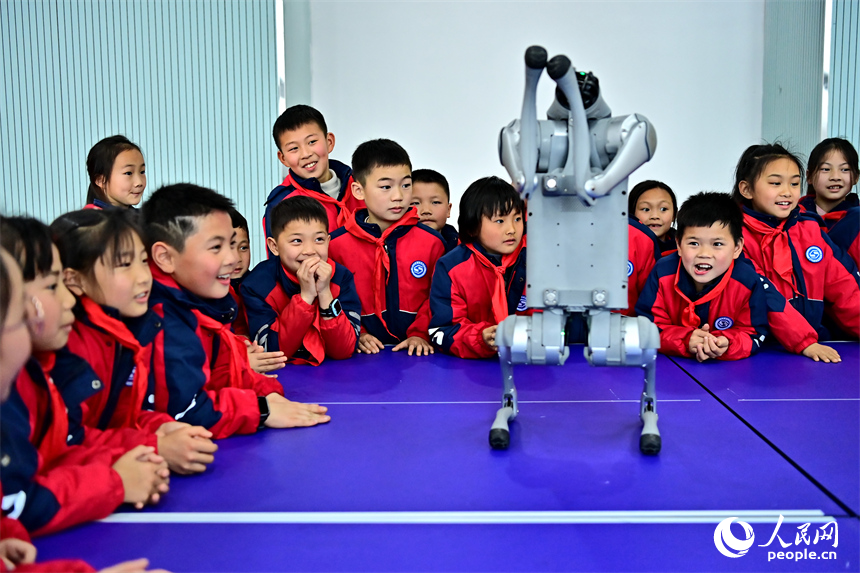 撫州市臨川區第五實驗學校人工智能科技小課堂上，學生在觀看仿生四足機器人表演。人民網 朱海鵬攝