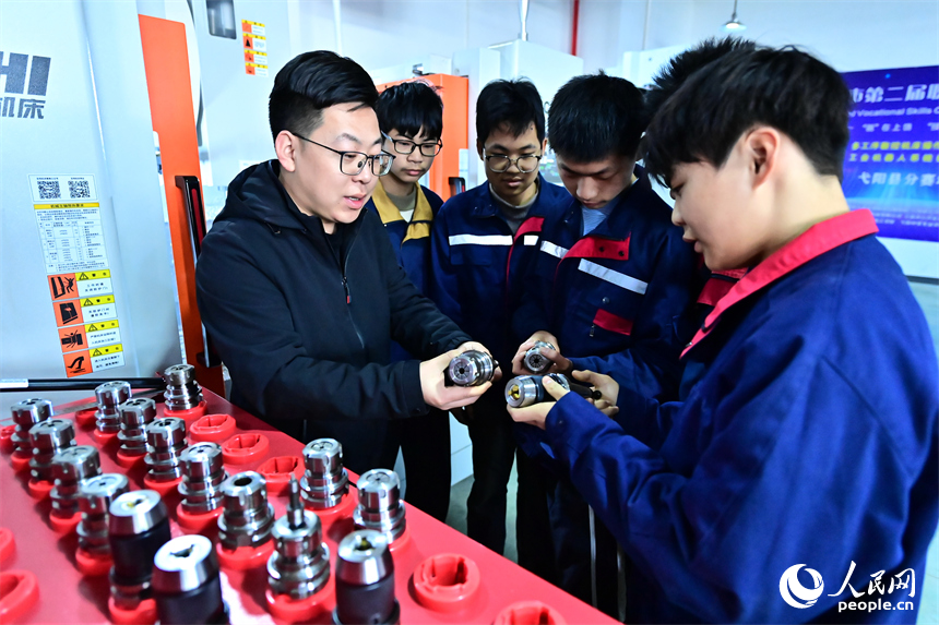 上饒市弋陽中等職業學校工業機器人實訓基地，學生在學習硬質合金零部件機械化加工技能。人民網 朱海鵬攝