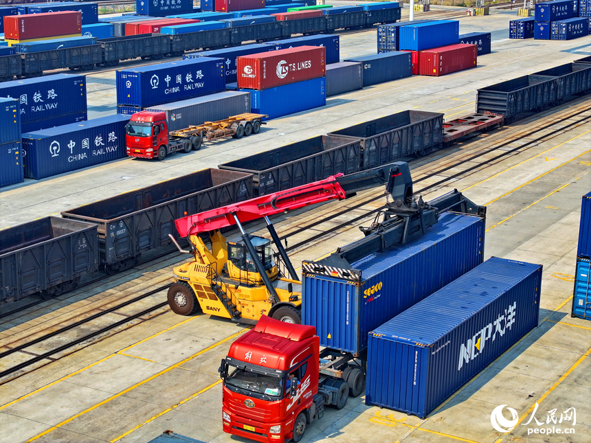 贛州國際陸港內的多式聯運貨物集裝箱裝運作業有序進行，貨場一派忙碌景象。人民網 朱海鵬攝