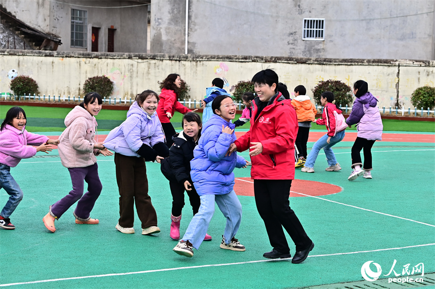 撫州市樂安縣龔坊鎮南邊村“幼吾幼”少兒之家，當地慈善總會的志愿者在和農村留守兒童一起交流互動，開展戶外健身游戲。人民網 朱海鵬攝