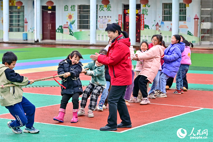撫州市樂安縣龔坊鎮南邊村“幼吾幼”少兒之家，當地慈善總會的志愿者在和農村留守兒童一起交流互動，開展戶外健身游戲。人民網 朱海鵬攝