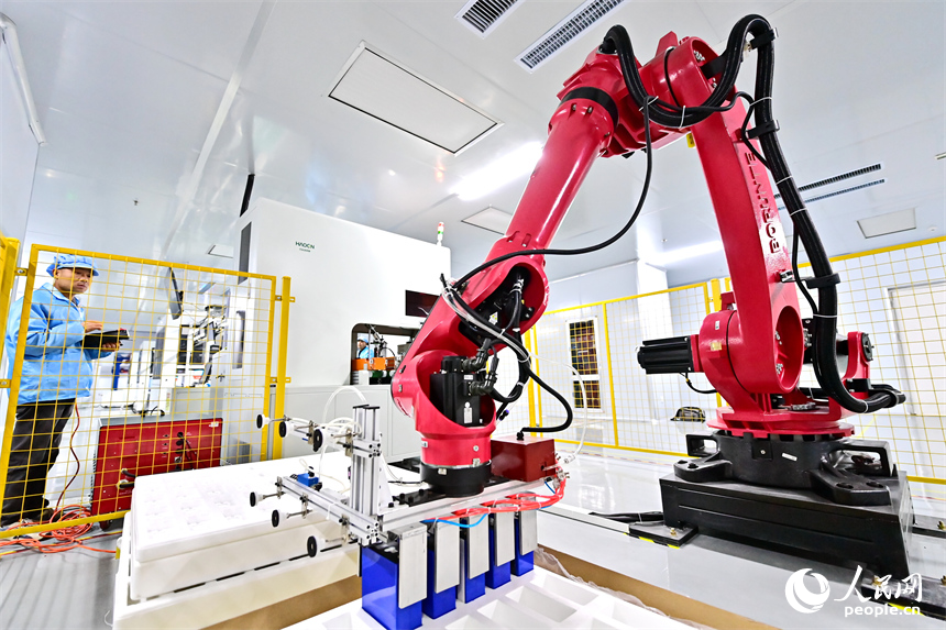 上饒市弋陽縣高新技術產業園區的科技企業車間內，工人在操作智能機械臂加工新能源汽車零部件。人民網 朱海鵬攝