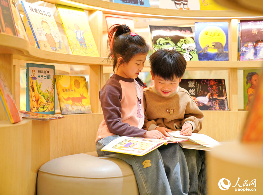 撫州市臨川區“拾光薈”購物廣場內的湯顯祖書店，小讀者被繪本故事吸引。人民網 朱海鵬攝