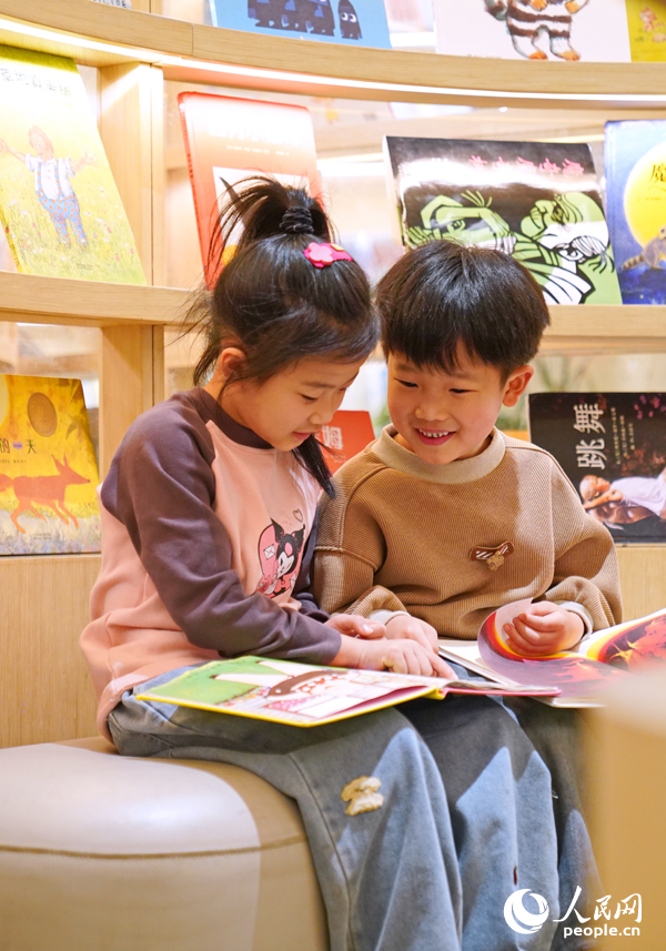 撫州市臨川區“拾光薈”購物廣場內的湯顯祖書店，小讀者被繪本故事吸引。人民網 朱海鵬攝
