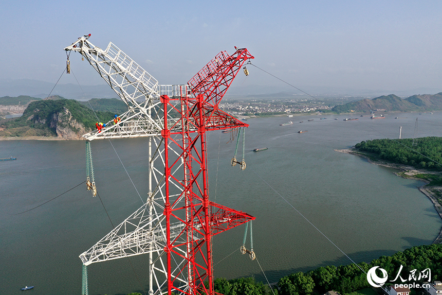 國家電網江西送變電中建公司施工人員正在電力鐵塔塔頂作業。人民網記者 時雨攝
