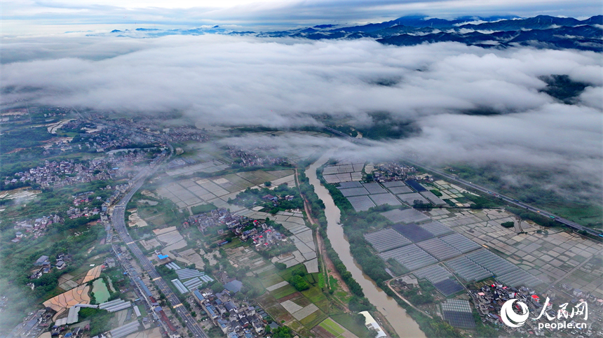 贛州市大余縣黃龍鎮葉敦村，寬闊的鄉村公路與蜿蜒河流、連綿青山相映成景。人民網 朱海鵬攝