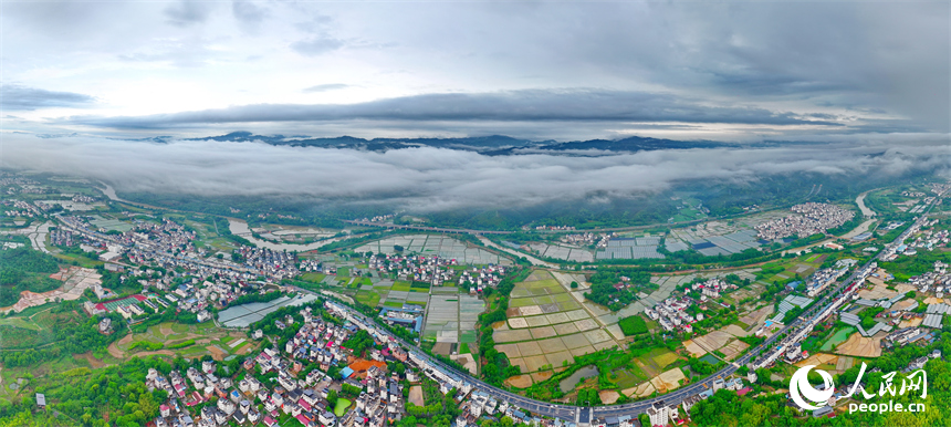 贛州市大余縣黃龍鎮葉敦村，寬闊的鄉村公路與蜿蜒河流、連綿青山相映成景。人民網 朱海鵬攝