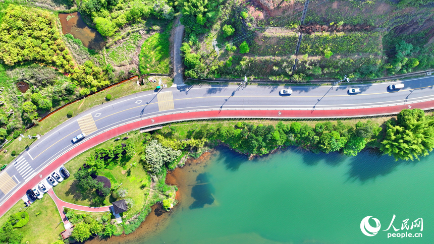 贛州市上猶縣東山鎮，車輛在環湖公路行駛，沿線水清岸綠景美春意濃。人民網 朱海鵬攝