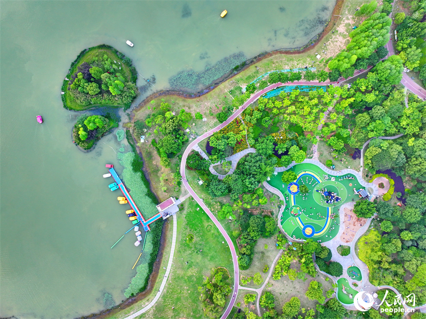 贛州市中心城區的一處公園里，家長帶著孩子在兒童游樂園內游玩，樂享親子時光。人民網 朱海鵬攝