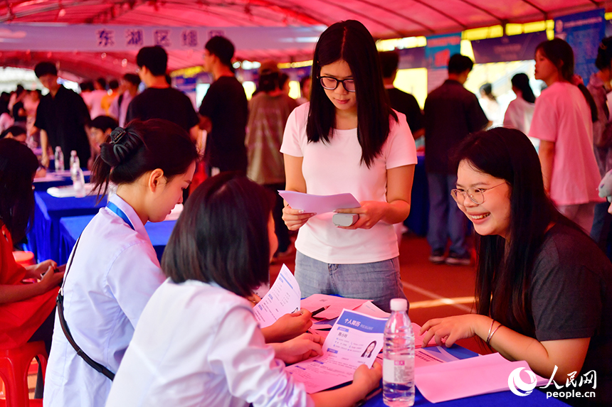 “國聘行動”現場，高校畢業生正在跟企業招聘人員交談。人民網記者 時雨攝