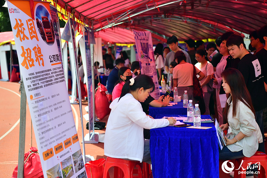 “國聘行動”現場，高校畢業生正在跟企業招聘人員交談。人民網記者 時雨攝
