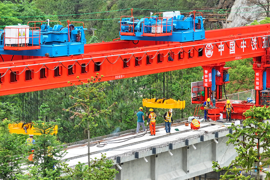 瑞金市澤覃鄉，大型架梁機平穩前移，工人在架設瑞梅鐵路橋梁。人民網 朱海鵬攝