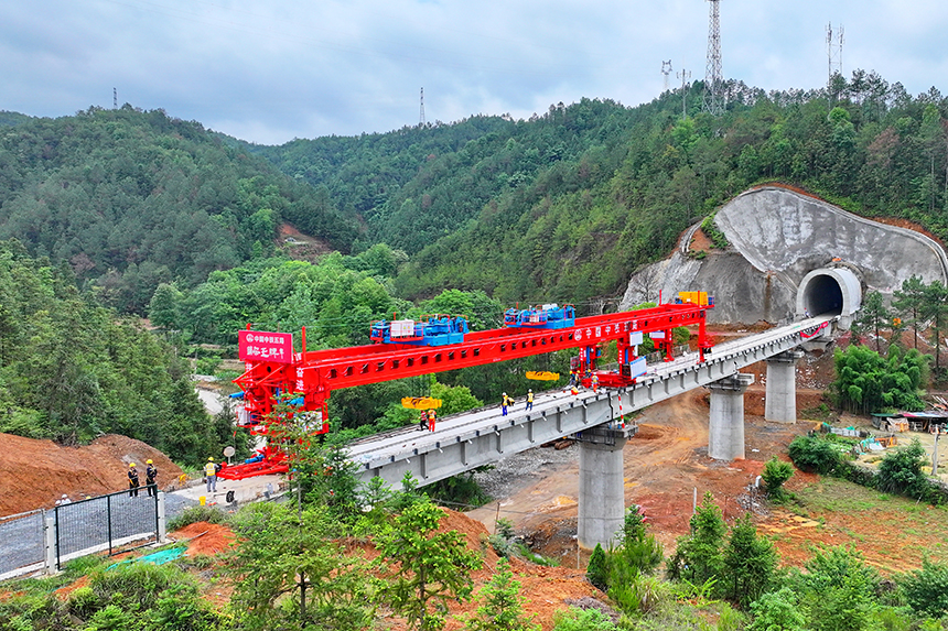 瑞金市澤覃鄉，大型架梁機平穩前移，工人在架設瑞梅鐵路橋梁。人民網 朱海鵬攝