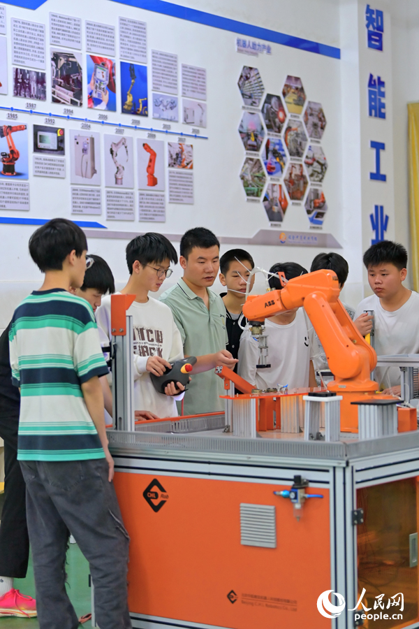 瑞金市瑞金中等專業學校工業機器人實訓基地，老師在指導學生在操作智能機械臂。人民網 朱海鵬攝