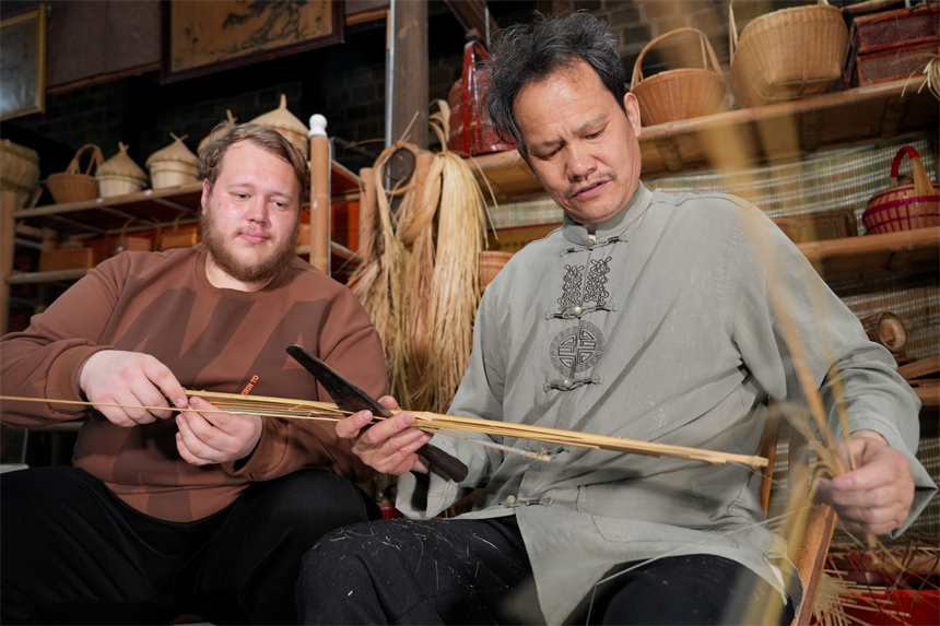 留學生白熙華正在向徐建元學習篾絲制作。人民網 孔文進攝