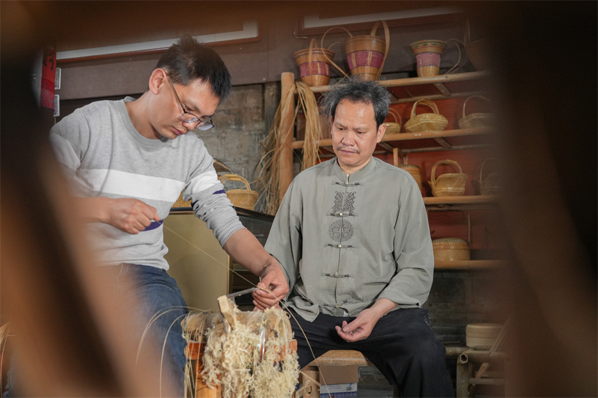 徐建元在指導兒子徐志俊制作篾絲。人民網 孔文進攝