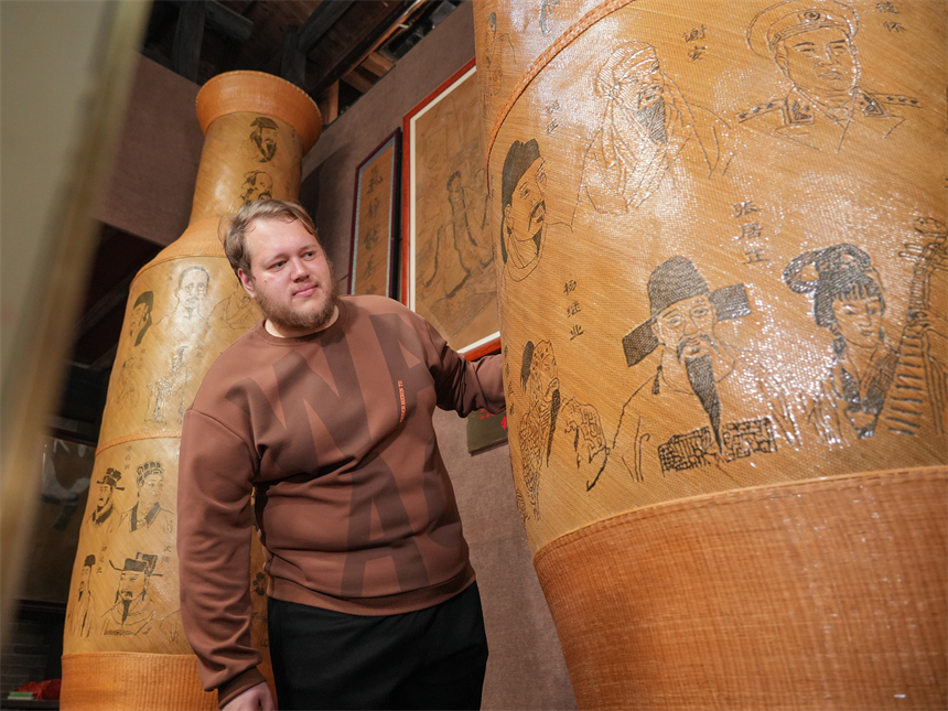 留學生白熙華在欣賞徐建元的篾編作品。人民網 孔文進攝