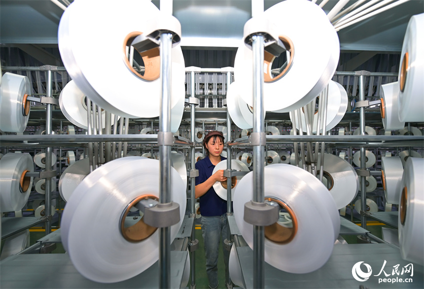 瑞金市的一家化纖紡織企業，工人在生產線上趕制出口東南亞國家的產品訂單。人民網 朱海鵬攝