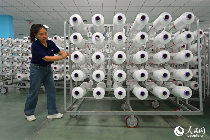 瑞金市的一家化纖紡織企業，工人在生產線上趕制出口東南亞國家的產品訂單。人民網 朱海鵬攝