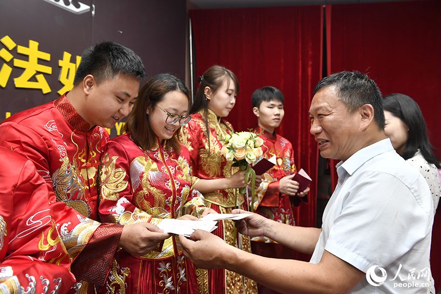 婚姻登記中心工作人員為新人們頒發結婚證。人民網記者 時雨攝