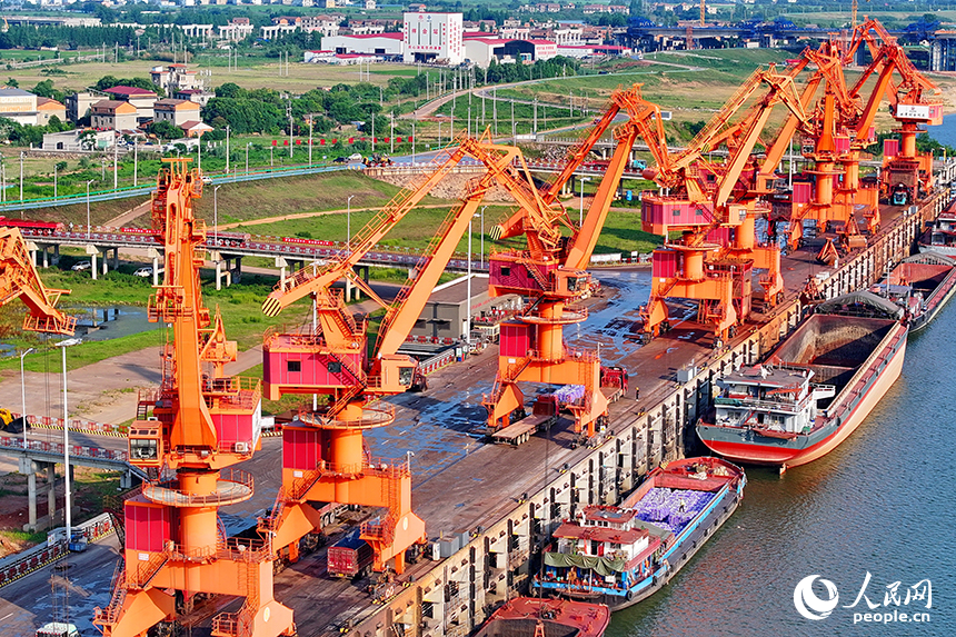南昌市南昌縣富山鄉贛江河畔，姚灣綜合碼頭船來船往，裝卸運輸設備有序運轉，一派繁忙景象。人民網 朱海鵬攝