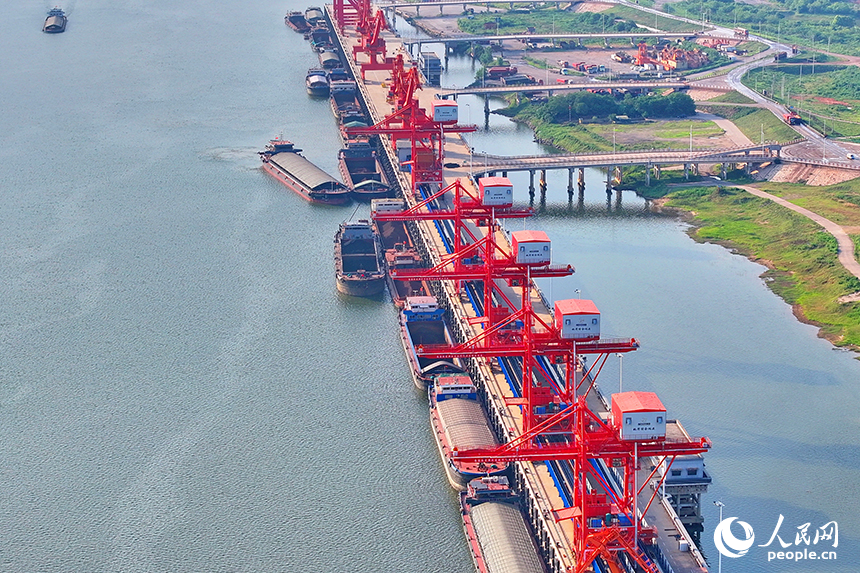 南昌市南昌縣富山鄉贛江河畔，姚灣綜合碼頭船來船往，裝卸運輸設備有序運轉，一派繁忙景象。人民網 朱海鵬攝