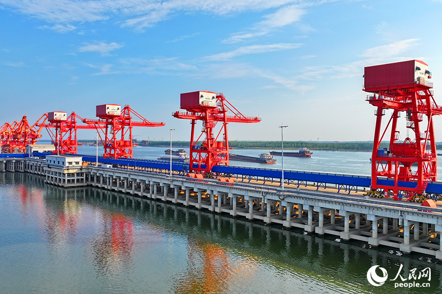 南昌市南昌縣富山鄉贛江河畔，姚灣綜合碼頭船來船往，裝卸運輸設備有序運轉，一派繁忙景象。人民網 朱海鵬攝