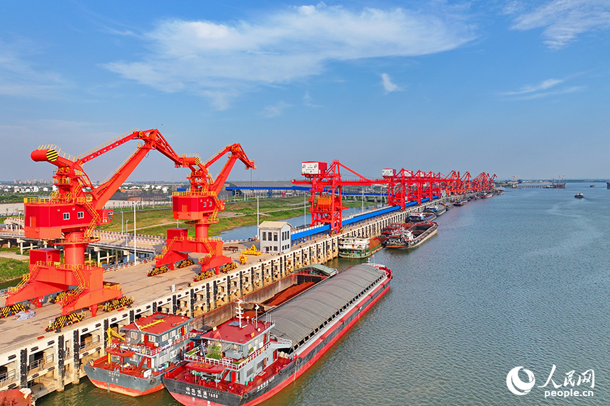 南昌市南昌縣富山鄉贛江河畔，姚灣綜合碼頭船來船往，裝卸運輸設備有序運轉，一派繁忙景象。人民網 朱海鵬攝