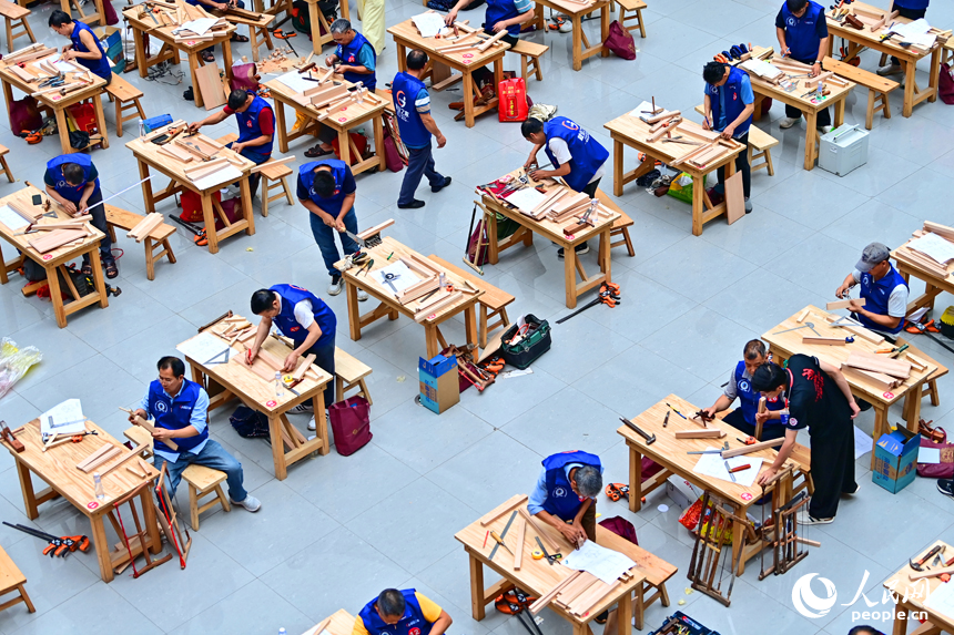 贛州市南康區家居小鎮博覽中心，幾十名木匠工人在手工木工（木制家具工）職業技能競賽決賽中制作家具。人民網 朱海鵬攝