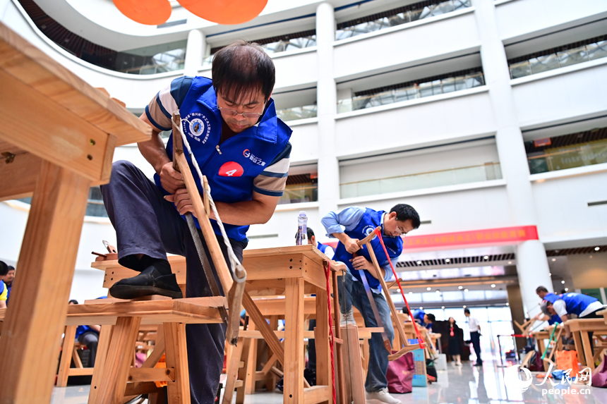 贛州市南康區家居小鎮博覽中心，幾十名木匠工人在手工木工（木制家具工）職業技能競賽決賽中制作家具。人民網 朱海鵬攝