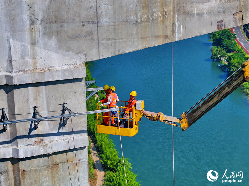 贛州市上猶縣陡水鎮的遂大高速上猶江特大橋項目施工現場，工人在進行大橋收尾施工。人民網 朱海鵬攝