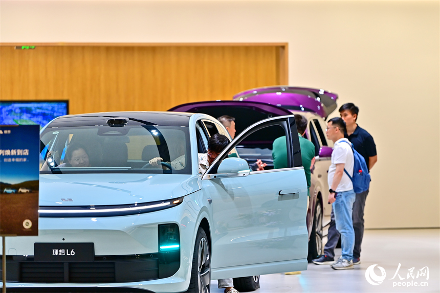 顧客在了解選購車型，咨詢汽車“以舊換新”補貼政策。人民網 朱海鵬攝