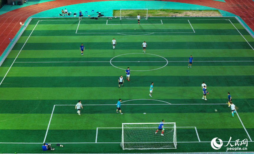 市民們在南昌市贛江畔的體育公園踢足球。人民網記者 毛思遠攝