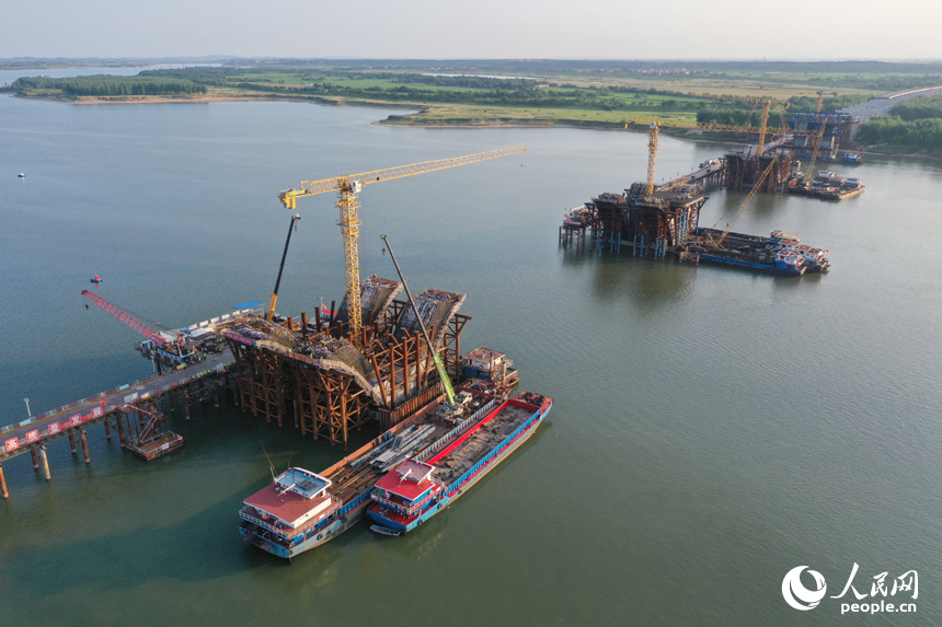 昌南大橋的施工現場塔吊林立，施工人員在汛期搶抓工期，為大橋建設按下“快進鍵”。人民網記者 時雨攝