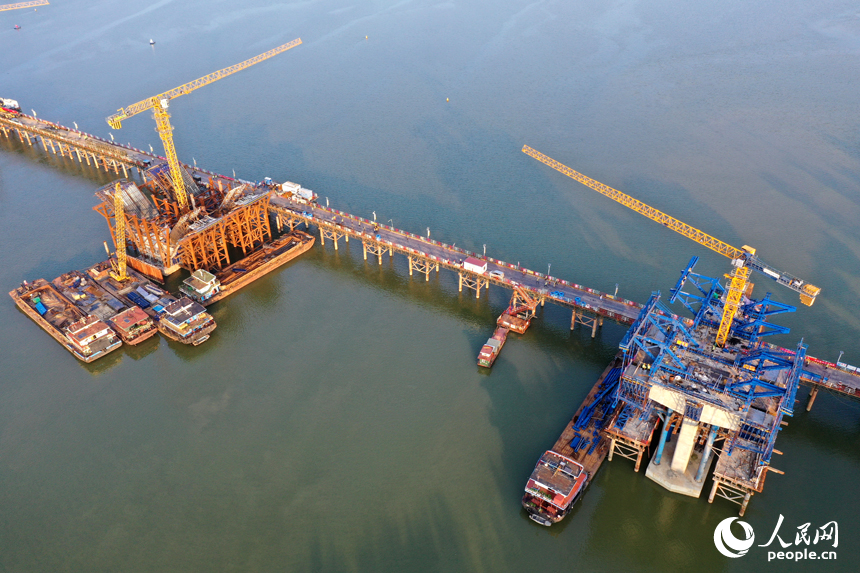 昌南大橋的施工現場塔吊林立，施工人員在汛期搶抓工期，為大橋建設按下“快進鍵”。人民網記者 時雨攝