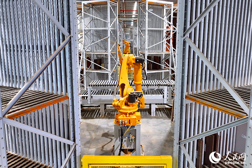 智能制造企業車間內，智能機器人手臂快速運轉，板材分揀包裝有序進行。人民網 朱海鵬攝